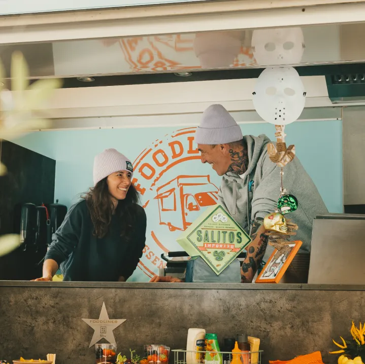 Bernd Müller und seine Ehefrau im Foodliner-Foodtruck, bereit für ein Business-Event – frische Zutaten und erstklassiger Service für Firmenfeiern und Team-Events.